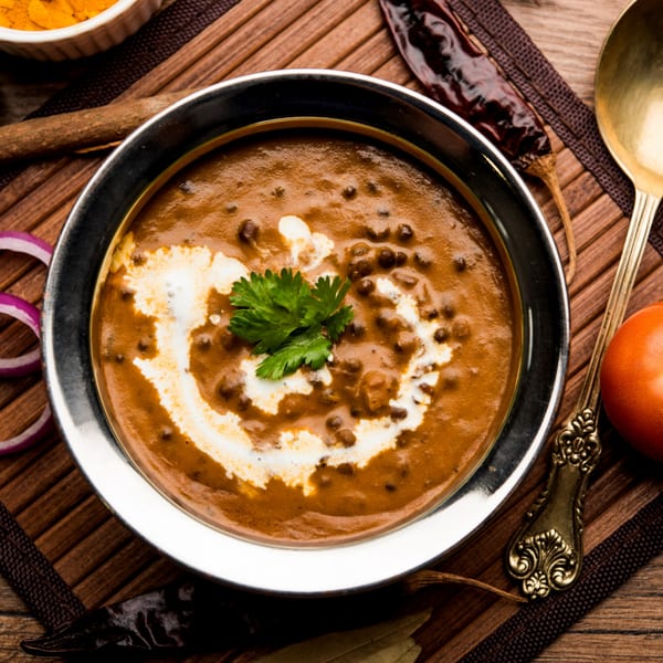 A bowl of creamy Indian Dal Makhani, garnished with fresh cilantro and a swirl of cream.