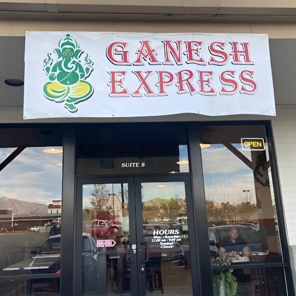 Exterior of Ganesh Express restaurant with a banner featuring the Ganesh logo and name above the entrance.